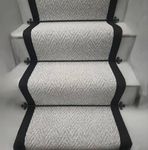 Light grey carpet stair runner with black taped edge