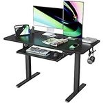 FEZIBO Height Adjustable Electric Standing Desk with Keyboard Tray, 120 x 60 cm Sit Stand up Desk with Splice Board, Black Frame/Black Top